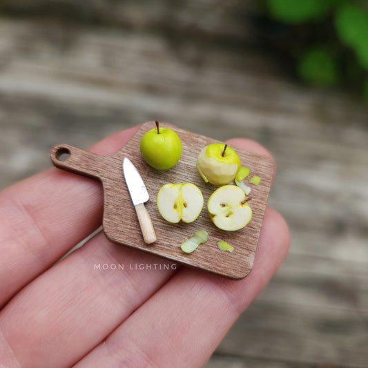 Miniature chopping board with big green apples