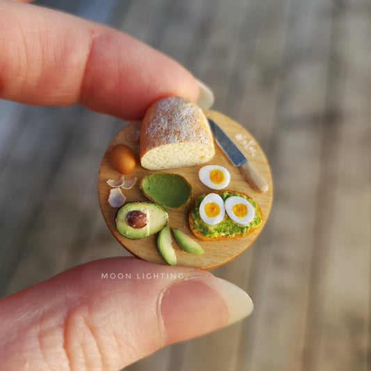 Avocado toast with eggs on round board with knife